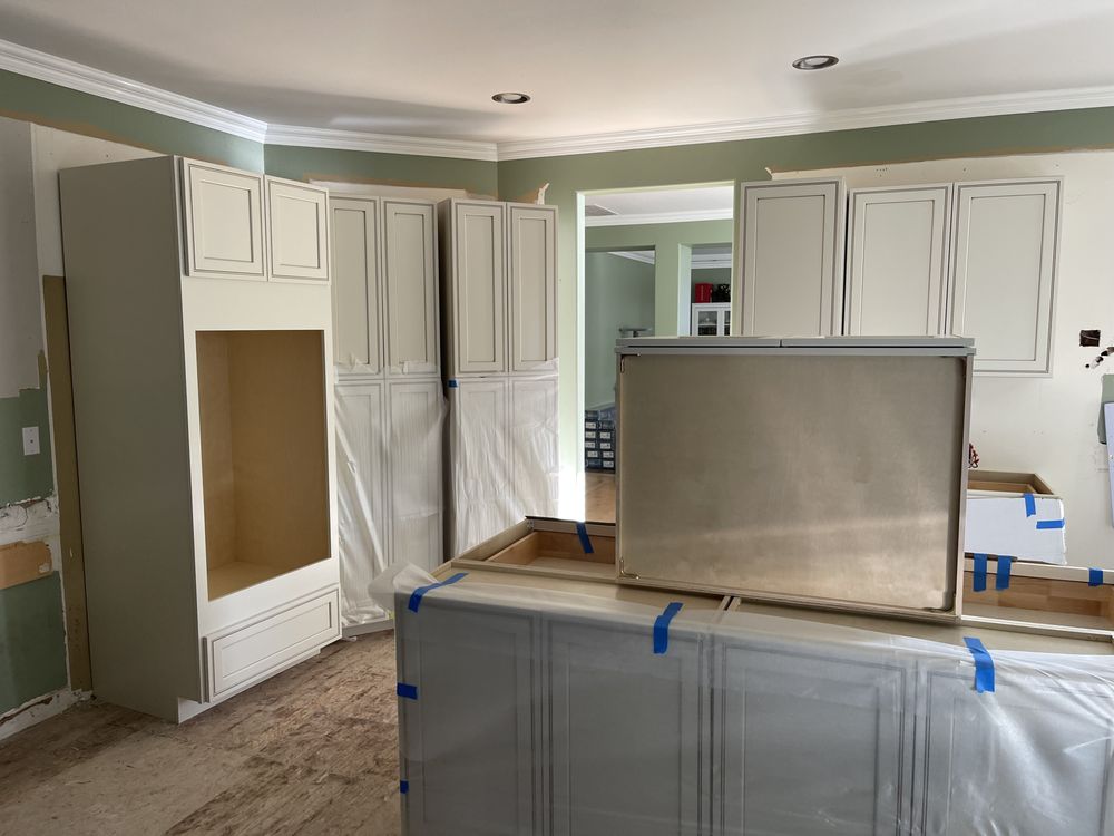 Kitchen renovation in progress with custom white cabinets